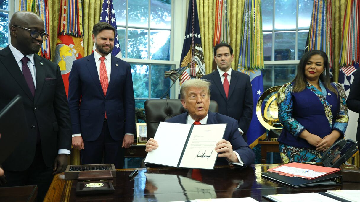 Le président américain Donald Trump signe une lettre de félicitations lors de sa rencontre avec le ministre rwandais des Affaires étrangères et de la Coopération, Olivier Nduhungirehe, et la ministre des Affaires étrangères de la République démocratique du Congo, Thérèse Kayikwamba Wagner, dans le bureau ovale de la Maison Blanche, le 27 juin 2025.