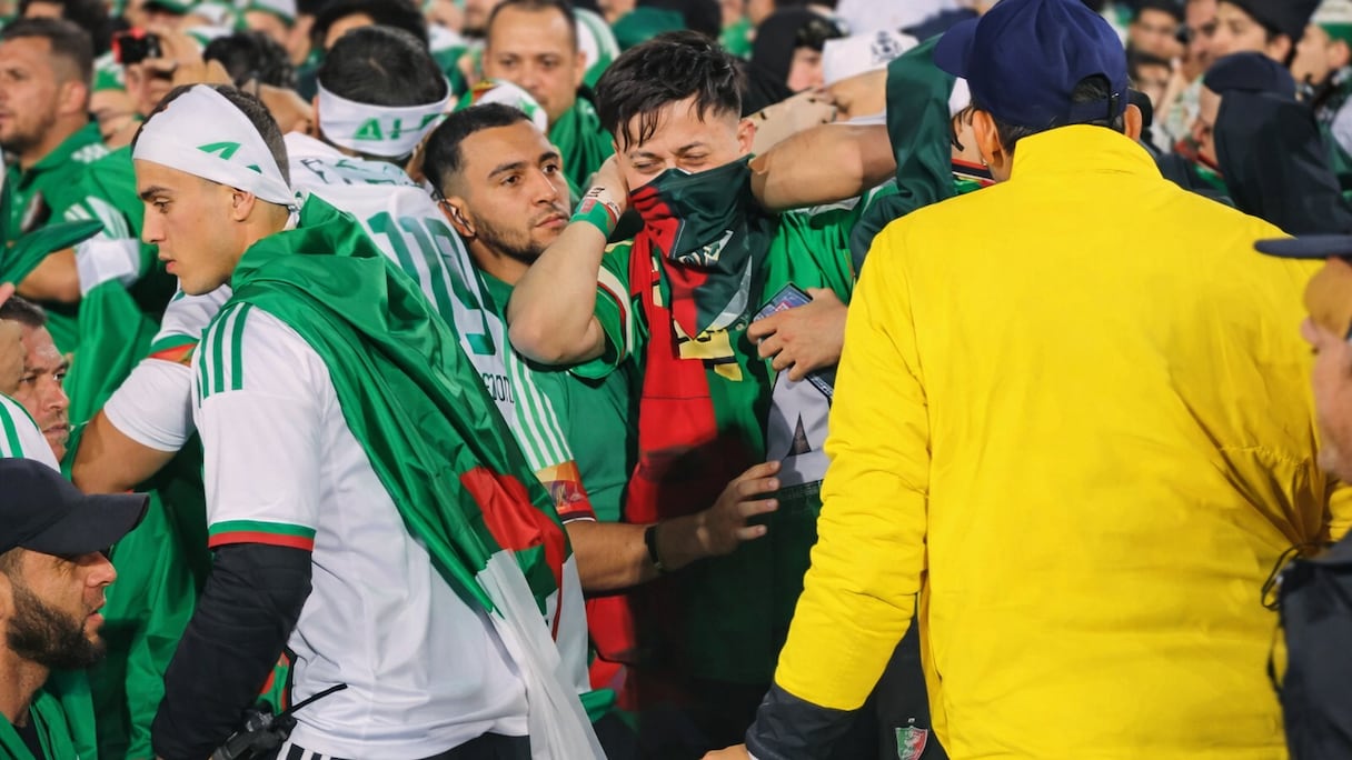 A gauche, le supporter algérien avec le talkie-walkie volé en main.