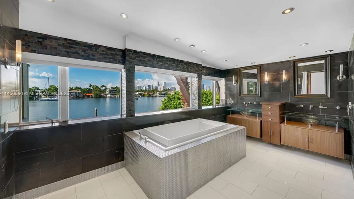 La salle de bain principale dispose d'un double lavabo, d'une douche à l'italienne et d'une baignoire donnant sur la baie de Biscayne.