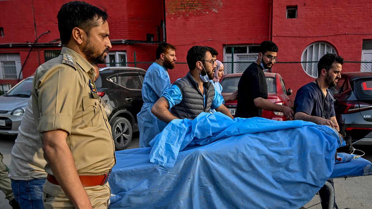 Des ambulanciers et des policiers transportent un touriste blessé dans un hôpital d'Anantnag, au sud de Srinagar, le 22 avril 2025, après une attaque