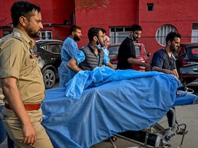 Des ambulanciers et des policiers transportent un touriste blessé dans un hôpital d'Anantnag, au sud de Srinagar, le 22 avril 2025, après une attaque