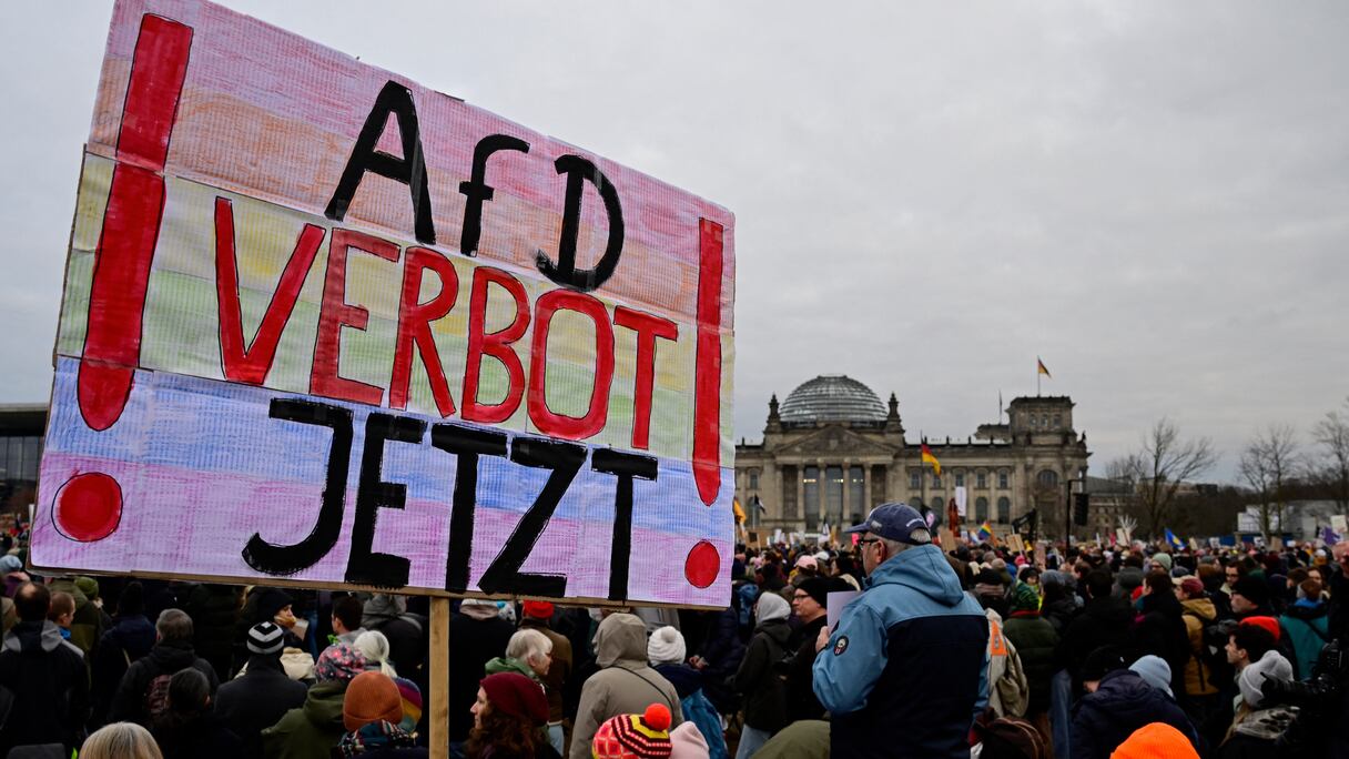 Un manifestant brandit une pancarte appelant à l'interdiction du parti d'extrême droite Alternative pour l'Allemagne (AfD) lors d'une manifestation sous la devise «Fort contre les nazis» devant le bâtiment du Reichstag à Berlin le 2 février 2025