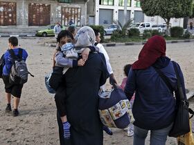 Des Palestiniens se dirigent vers les bureaux de l'ONU à Gaza pour se mettre en sécurité après que plusieurs bâtiments aient été pris pour cible, aux premières heures du 12 mai 2021.