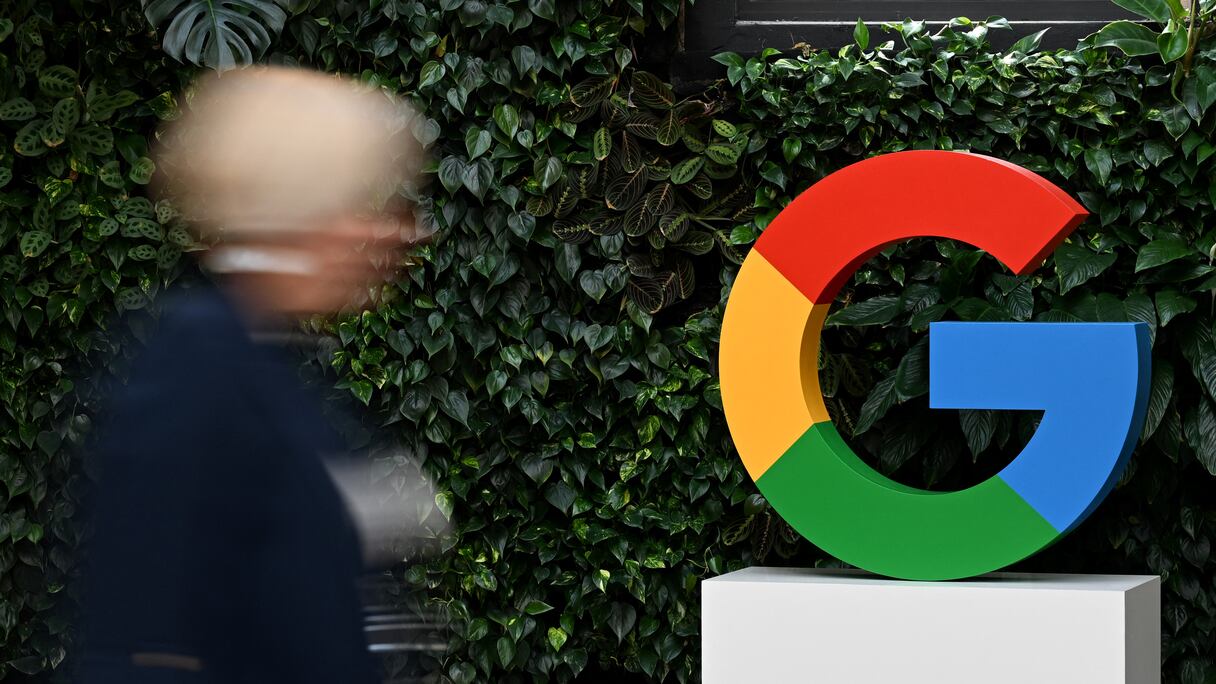 Une femme passe devant un logo Google sur le campus Google de Varsovie, le 13 février 2025