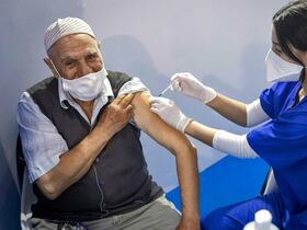 ممرضة تحقن شخصا باللقاح المضاد لفيروس كورونا