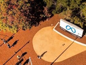 Des personnes passent devant le logo de Meta, le nouveau nom de la société-mère de Facebook, qui effectue une transition vers sa vision de la réalité virtuelle pour l'avenir, au siège social de la compagnie, à Menlo Park (Californie), le 28 octobre 2021.