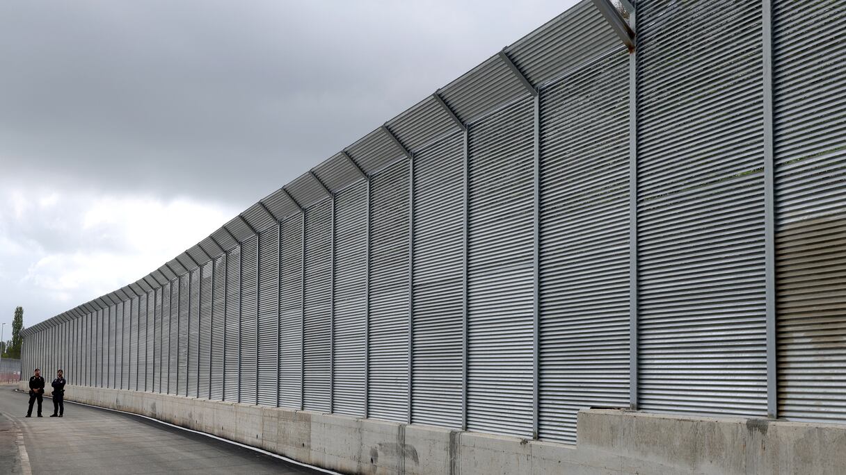 Des policiers italiens se tiennent devant la clôture d'un centre de migrants récemment construit par l'Italie dans le port de Shengjin, à environ 60 km au nord-ouest de Tirana, le 11 octobre 2024