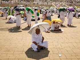 Les pèlerins musulmans utilisent des parapluies pour se protéger du soleil lorsqu'ils arrivent au pied du mont Arafat, lors du pèlerinage annuel du hajj, le 15 juin 2024