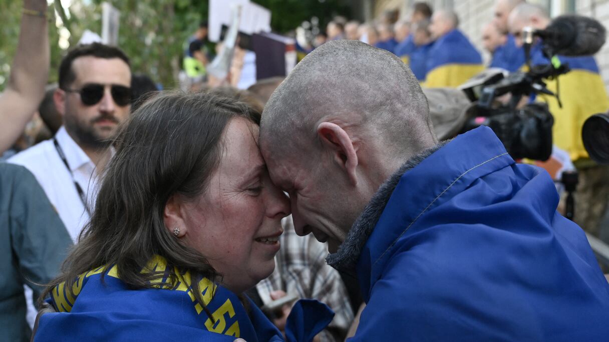 Le prisonnier de guerre ukrainien Oleksandr, 45 ans, embrasse sa femme Olena, 39 ans, à son arrivée après un échange de prisonniers dans la région de Tchernygiv le 23 mai 2025