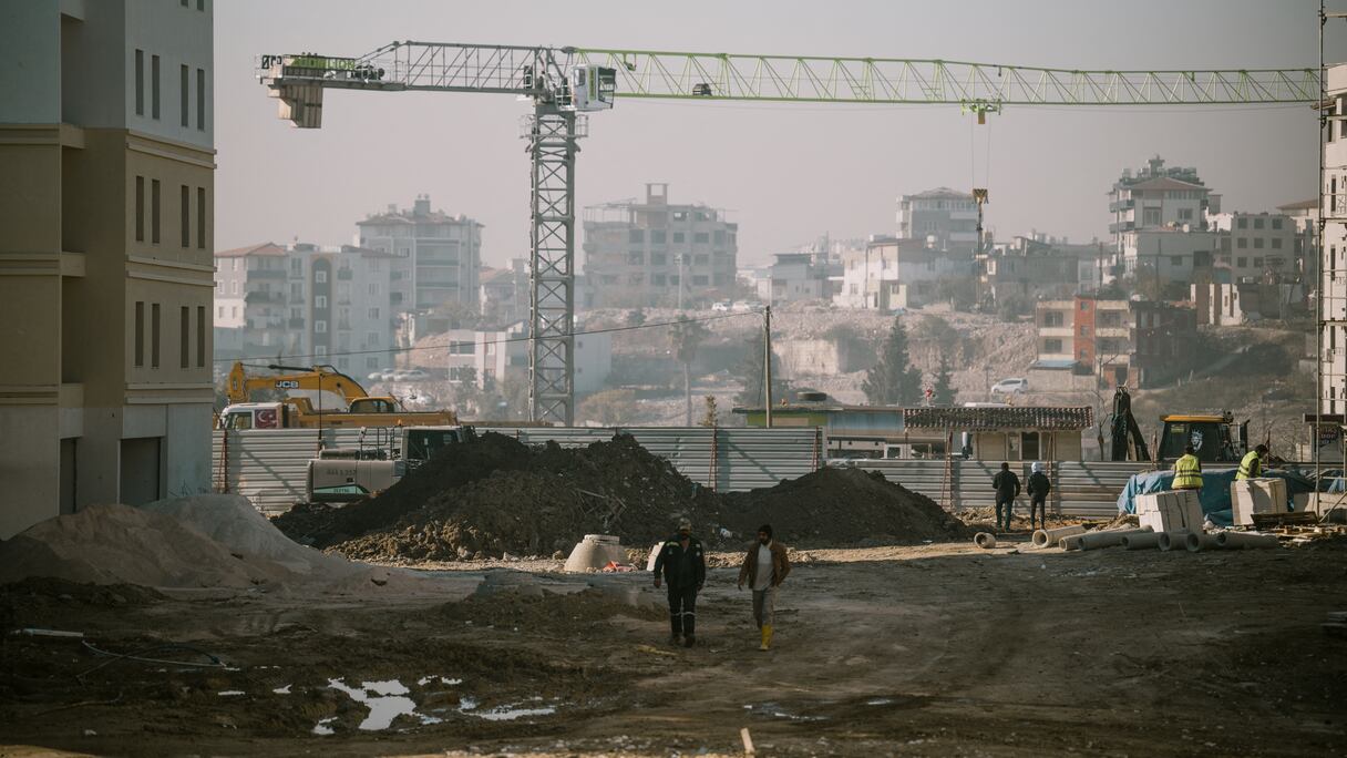 Des ouvriers travaillent dans la zone de construction de l'agence turque de logement public (TOKI) à Antakya le 28 janvier 2025