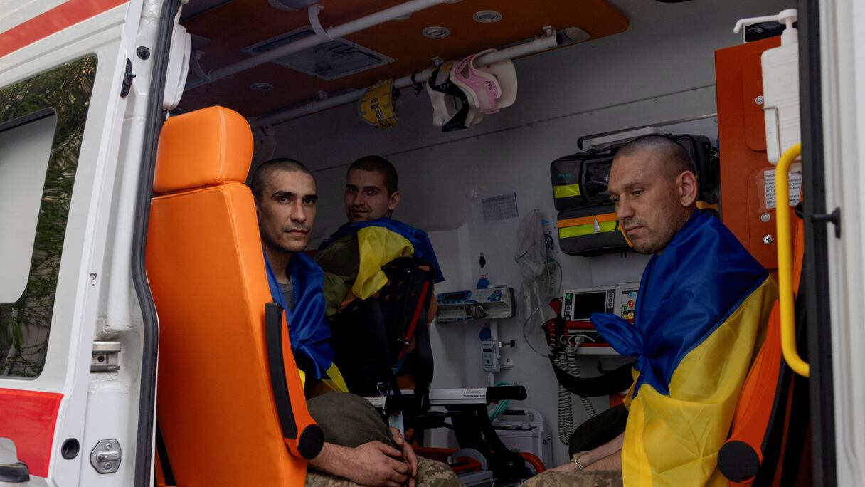 Des prisonniers ukrainiens libérés sont assis dans une ambulance à leur arrivée après un échange de prisonniers dans un lieu tenu secret en Ukraine, le 19 avril 2025, dans le contexte de l'invasion russe de l'Ukraine.