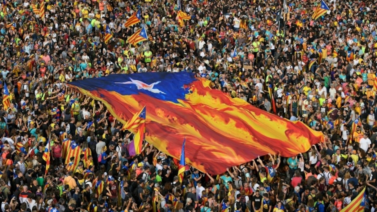 Des manifestants brandissent un drapeau de la région Catalogne, à Barcelone en Espagne.
