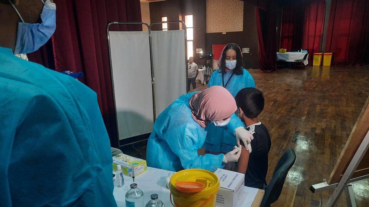 Un enfant reçoit une première dose du vaccin anti-Covid-19 dans un centre de vaccination à Guelmim, le 1er septembre 2021, lors d'une vaste opération pour 25.000 enfants et adolescents âgés de 12 à 17 ans de la région Guelmim-Oued Noun. 
