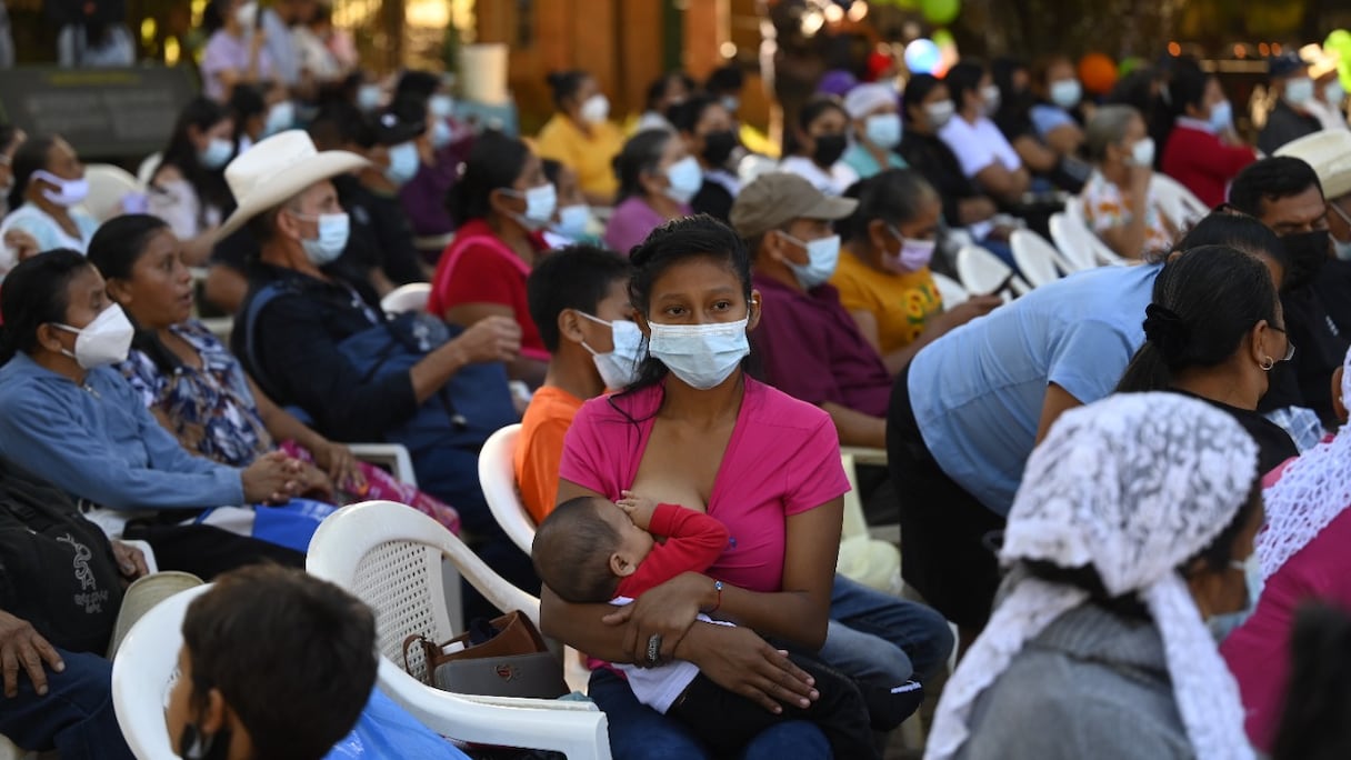 Une femme allaite son bébé lors d'une commémoration à El Mozote, à 200 km à l'est de San Salvador, le 11 décembre 2021.
