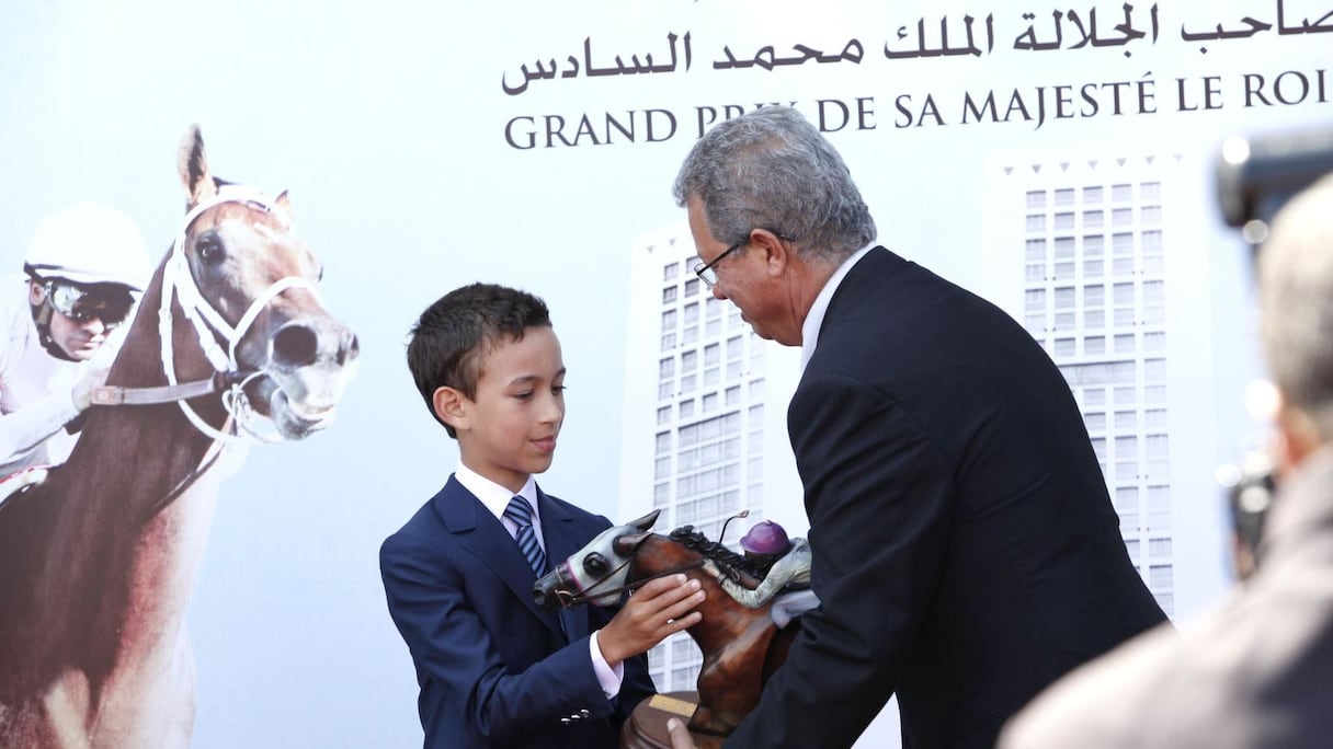 Kamal Daissaoui, propriétaire des deux étalons qui ont remporté le grand prix Moulay Rachid et le grand prix Moulay Hassan, reçoit ses trophées des mains du prince Héritier Moulay Hassan.
