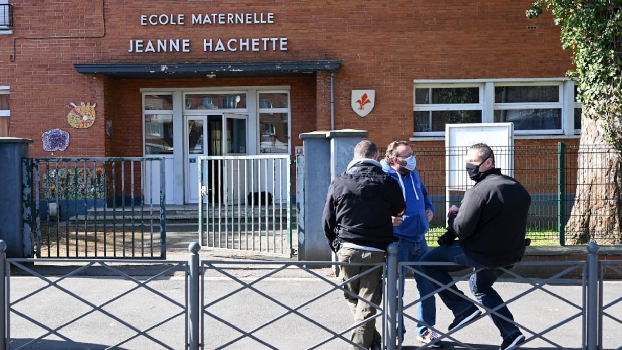 Des policiers en civil montent la garde devant l'école maternelle Béranger-Hachette à Lille, dans le nord de la France, le 23 avril 2021, après qu'une partie de l'école a été incendiée dans un incendie. 
