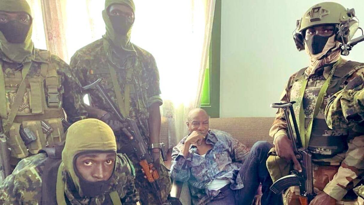 Des putchistes, vraisemblablement des mutins de l'armée régulière guinéenne, posent en tenue de combat devant le président Alpha Condé, qu'ils retiennent prisonnier, à la suite d'un coup d'Etat à Conakry, le 5 septembre 2021.