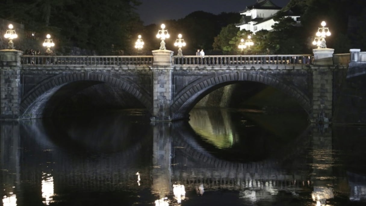 L'empereur Naruhito (G) et l'impératrice Masako sur un pont du Palais impérial à Tokyo, le 9 novembre 2019, pour accueillir les 30.000 personnes venues célébrer l'accession au trône du nouvel empereur.
