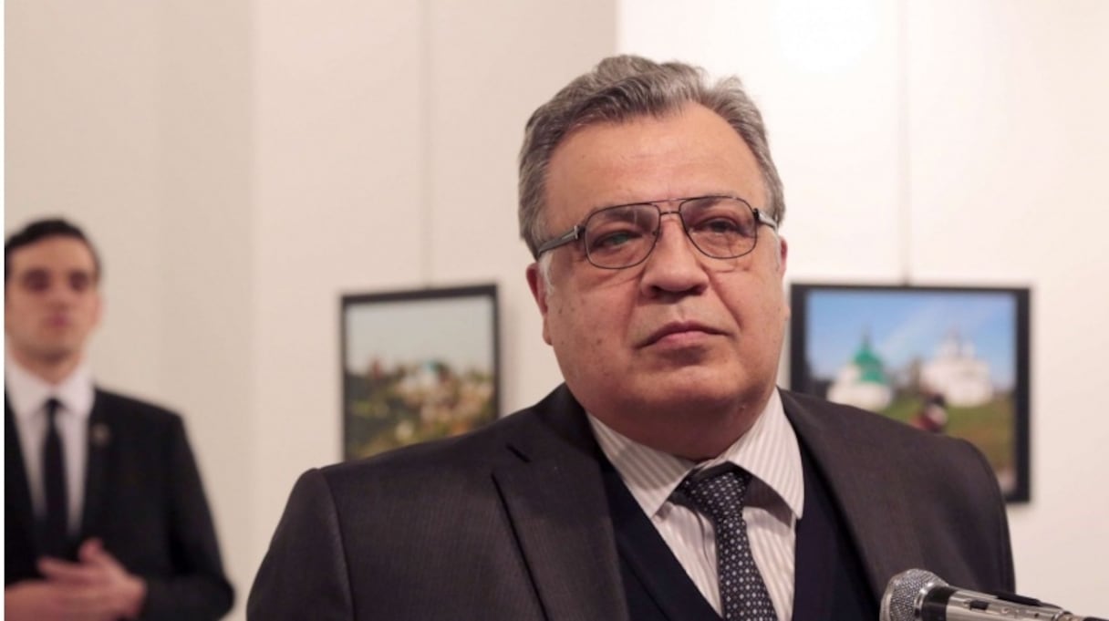 L'ambassadeur Andreï Karlov avant qu'il ne soit abattu par l'agent de sécurité, derrière lui.
