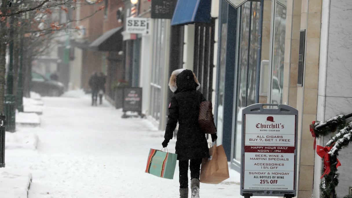 Des personnes bravent la météo pour faire leurs achats dans le centre-ville de Birmingham, dans le Michigan, le 23 décembre 2022.
