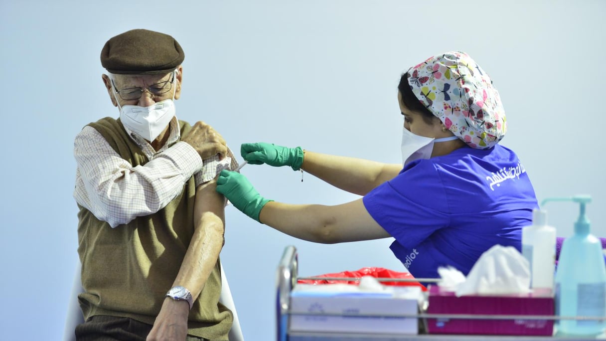 Une personne âgée reçoit une troisième dose du vaccin anti-Covid-19 à Salé, le 6 octobre 2021. Cette injection intervient dans le contexte de la vaccination de personnes ciblées, ayant reçu leurs deux premières doses depuis au moins six mois. 
