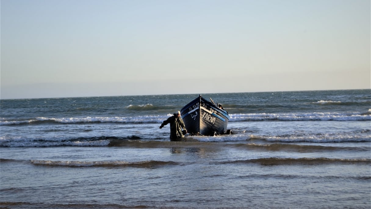 Pêcheurs sortant une barque de l'eau
