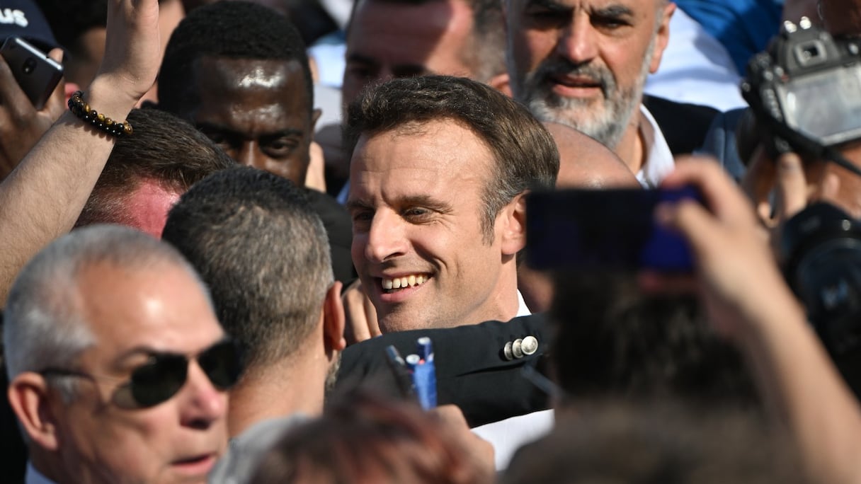 Le président français et candidat à la réélection de La République en marche (LREM), Emmanuel Macron, est entouré de partisans après une réunion de campagne électorale à Marseille, dans le sud de la France, le 16 avril 2022, avant le second tour du scrutin. 
