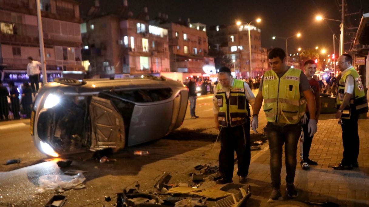 Un véhicule renversé gît sur la route sur les lieux d'une fusillade le 29 mars 2022 à Bnei Brak, à 7 km à l'est de Tel Aviv. Cinq personnes ont été tuées dans des attaques à l'arme à feu près de la ville côtière israélienne.
