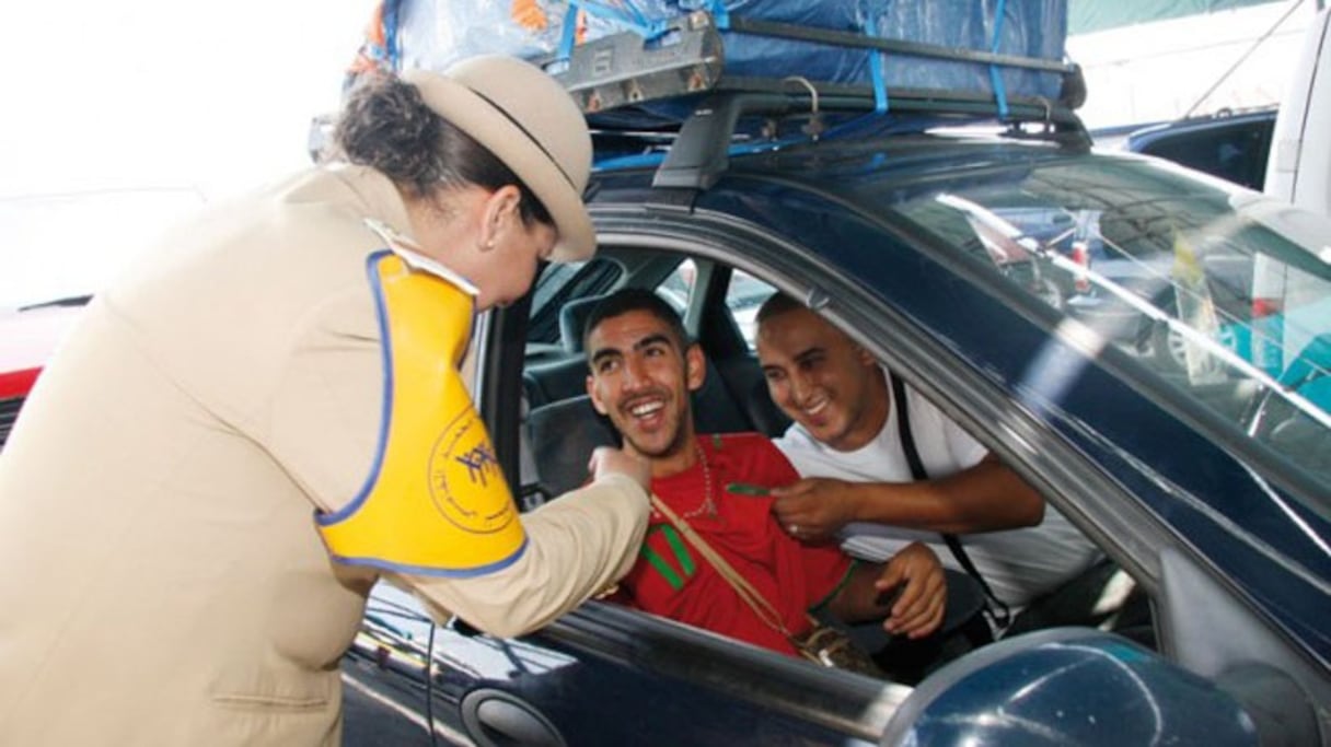 Des MRE accueillis à leur arrivée au Maroc par une membre de la fondation Mohammed V pour la Solidarité, lors d'une précédente opération Marhaba. 
