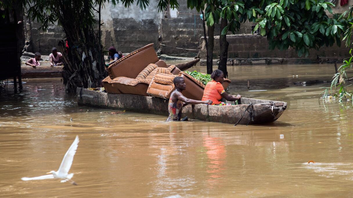 Des personnes transportent des meubles sur un bateau à Limete, une partie de Kinshasa, le 9 décembre 2015, après des inondations dans la capitale de la République démocratique du Congo.