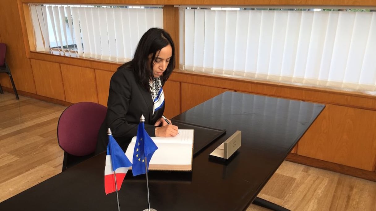 Mbarka Bouaida, signant le livre des condoléances à l'ambassade française à Rabat. 
