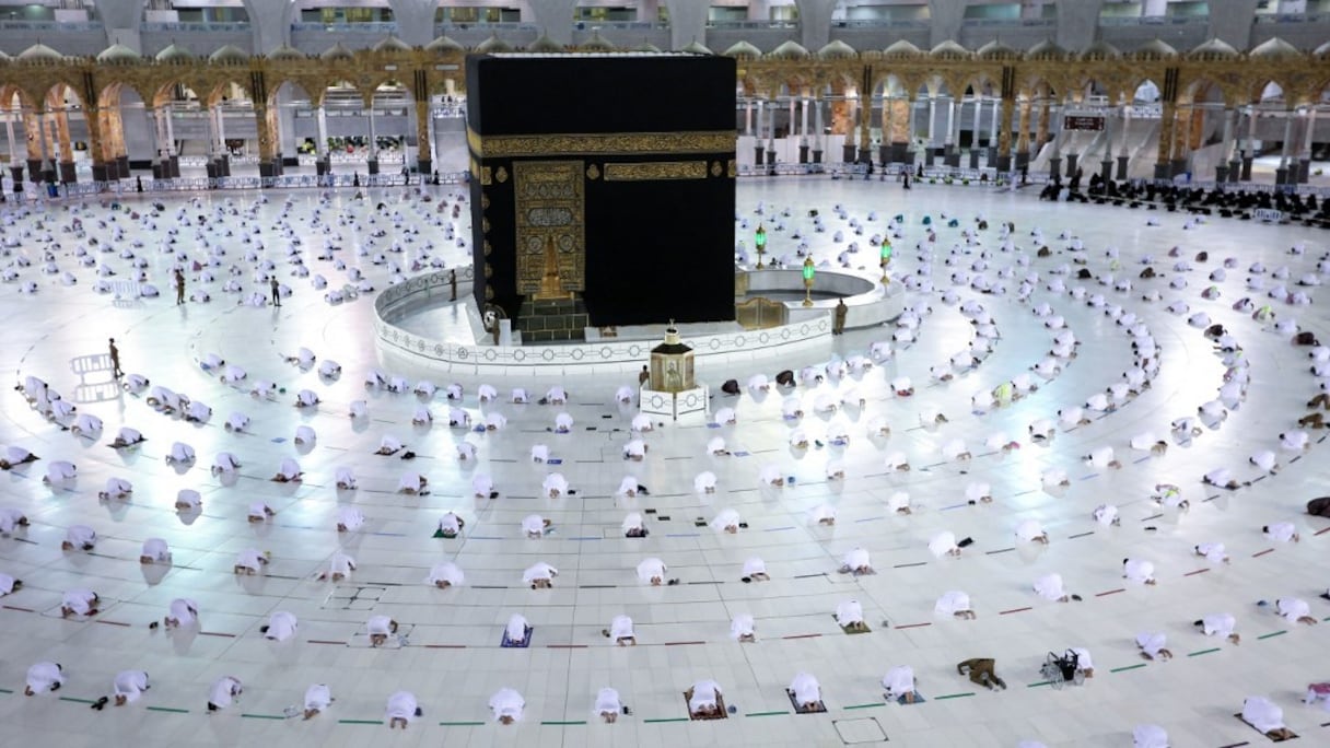 Des musulmans effectuent la prière des Tarawih au soir du premier jour du mois de jeûne du Ramadan, autour de la Kaaba dans le complexe de la Grande Mosquée de la ville sainte de La Mecque, le 13 avril 2021. 
