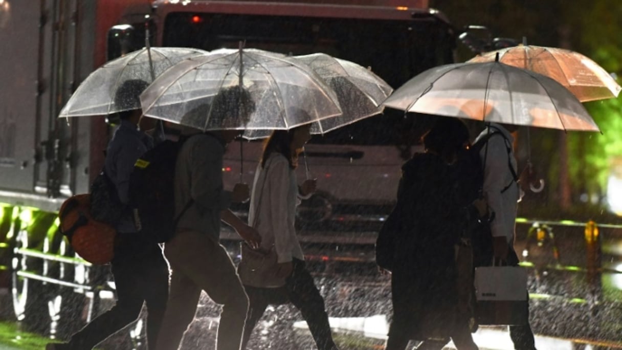 Des piétons affrontent une forte pluie due au passage du typhon Talim, le 17 septembre 2017 à Tokyo.
