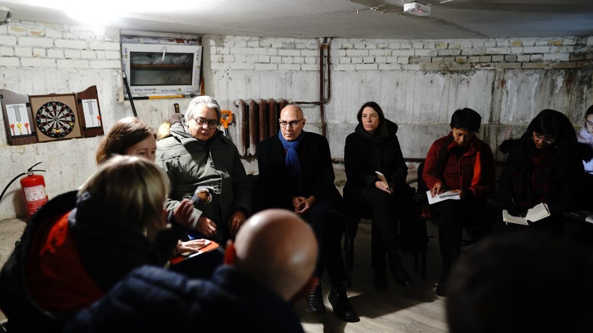 Volker Türk, Haut-Commissaire aux droits de l'homme (au centre, écharpe bleue) s'entretient avec des défenseurs des droits humains dans un abri souterrain, au cours d'une alerte de frappe aérienne à Kiev, le 5 décembre 2022, alors que l'invasion russe de l'Ukraine se poursuit.
