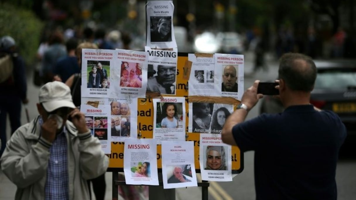 Des affiches avec des photos des résidents disparus dans la catastrophe de Grenfell Tower affichés près du Latymer Christian Center à Londres, le 16 juin 2017. 
