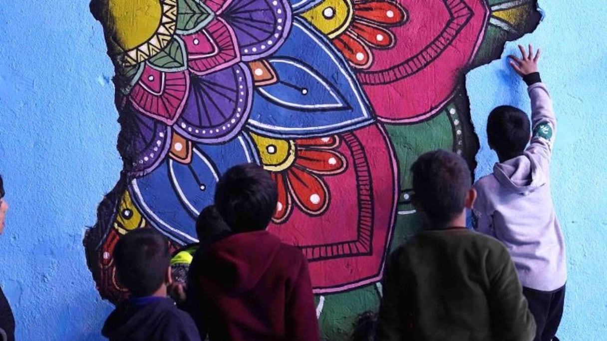 Enfants s'amusant dans la ruelle et admirant les nouvelles peintures murales.
