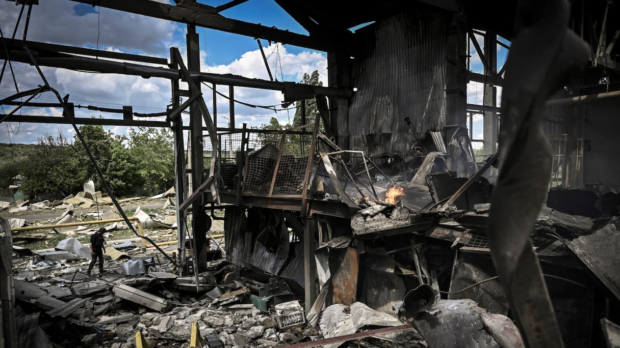 Un homme marche devant une usine de fabrication de gypse après le bombardement de la ville de Bakhmut dans la région ukrainienne orientale du Donbass, le 27 mai 2022.
