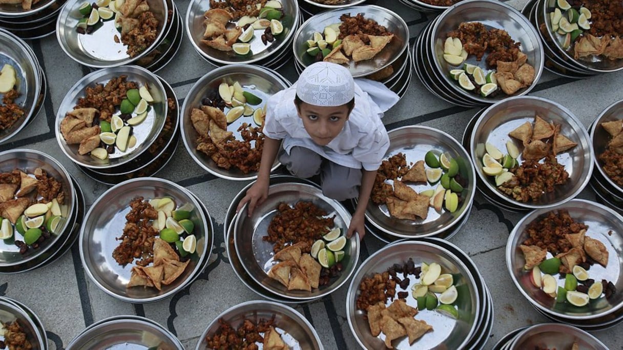 Au pieds d'une mosquée en Indonésie, ce jeune garçon prépare des assiettes du ftour pour les fidèles. 
