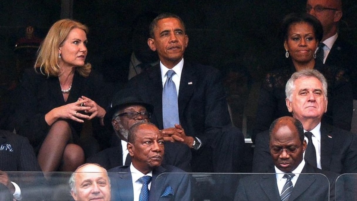 Barack Obama a l'air très concentré sur la scène où se déroulent les hommages à Nelson Mandela qu'il ne fait même pas attention au sourire pincé de son épouse juste à côté...
