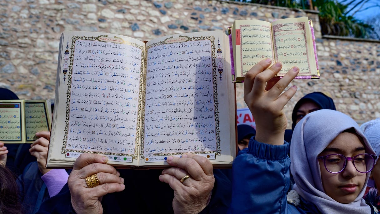 Des manifestants brandissent des copies du Coran, en signe de protestation, devant le consulat général de Suède à Istanbul le 22 janvier 2023. 
