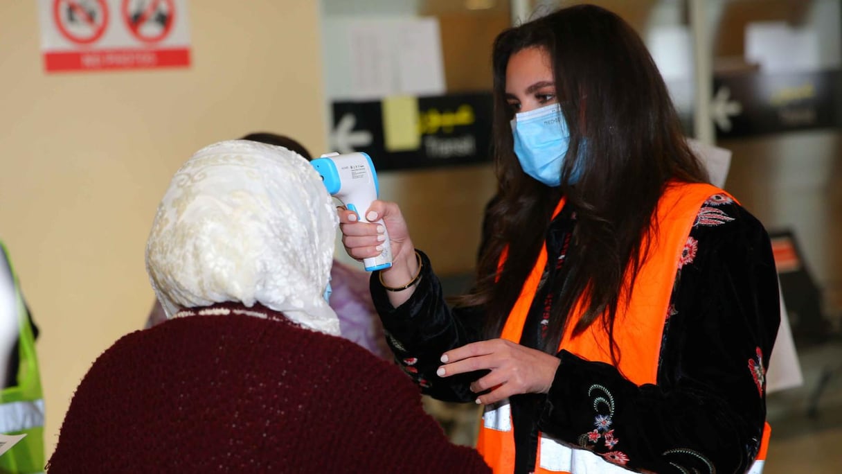 Prise de température d'une passagère à son arrivée, le 7 février 2022, à l'aéroport Mohammed V, conformément aux mesures préventives en vigueur.
