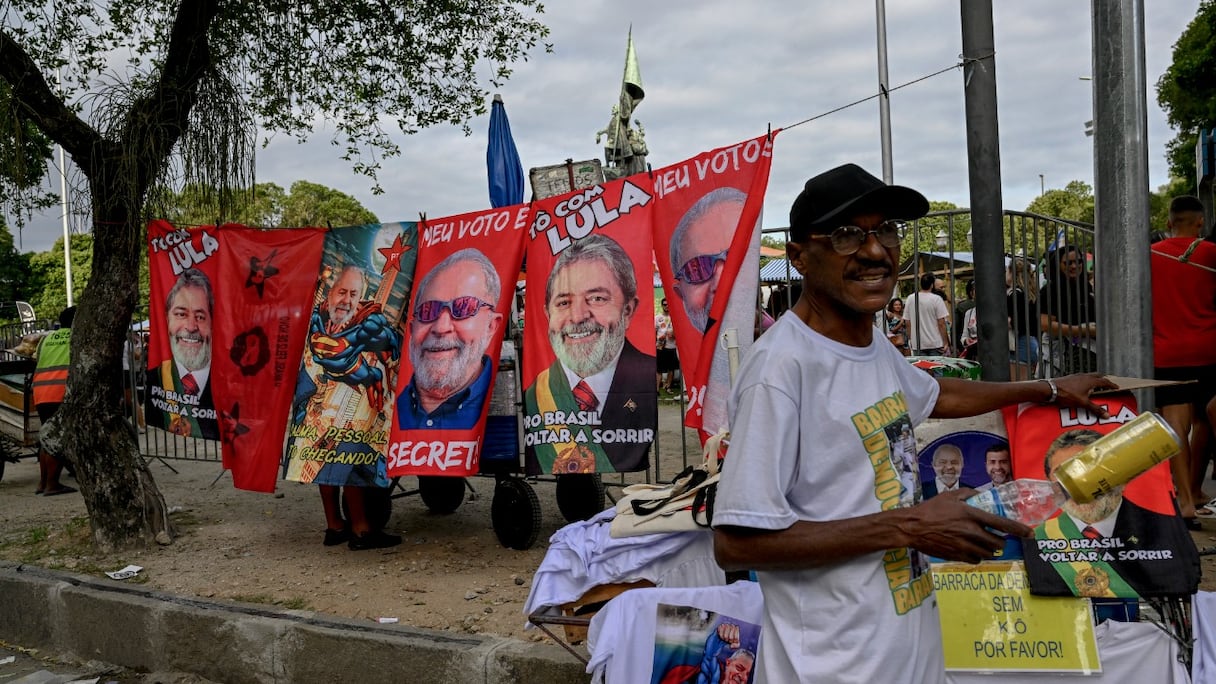 Un homme vend des serviettes et des drapeaux à l'effigie du candidat présidentiel du Brésil pour le Parti des travailleurs (PT) de gauche et ancien président (2003-2010) Luiz Inacio Lula da Silva dans le quartier Gloria à Rio de Janeiro, le 25 septembre 2022.
