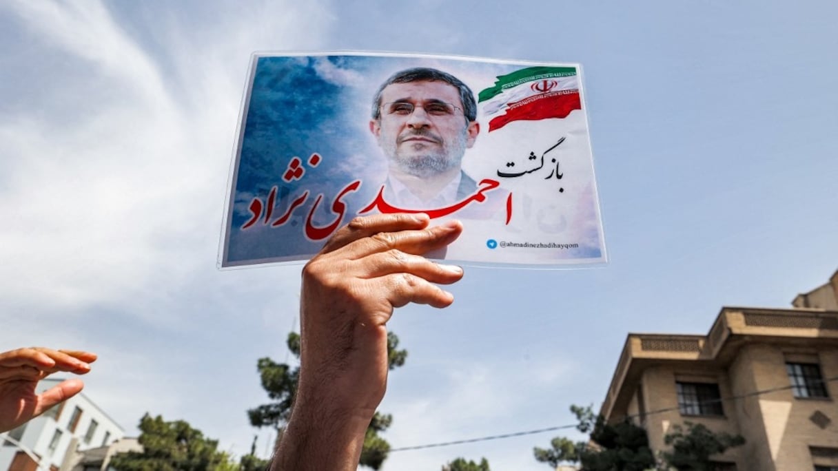 Un partisan de l'ancien président brandit un dépliant devant le siège du ministère de l'Intérieur à Téhéran, le 12 mai 2021, alors qu'Ahmadinejad vient enregistrer sa candidature pour se présenter à nouveau aux présidentielles prévues en juin.
