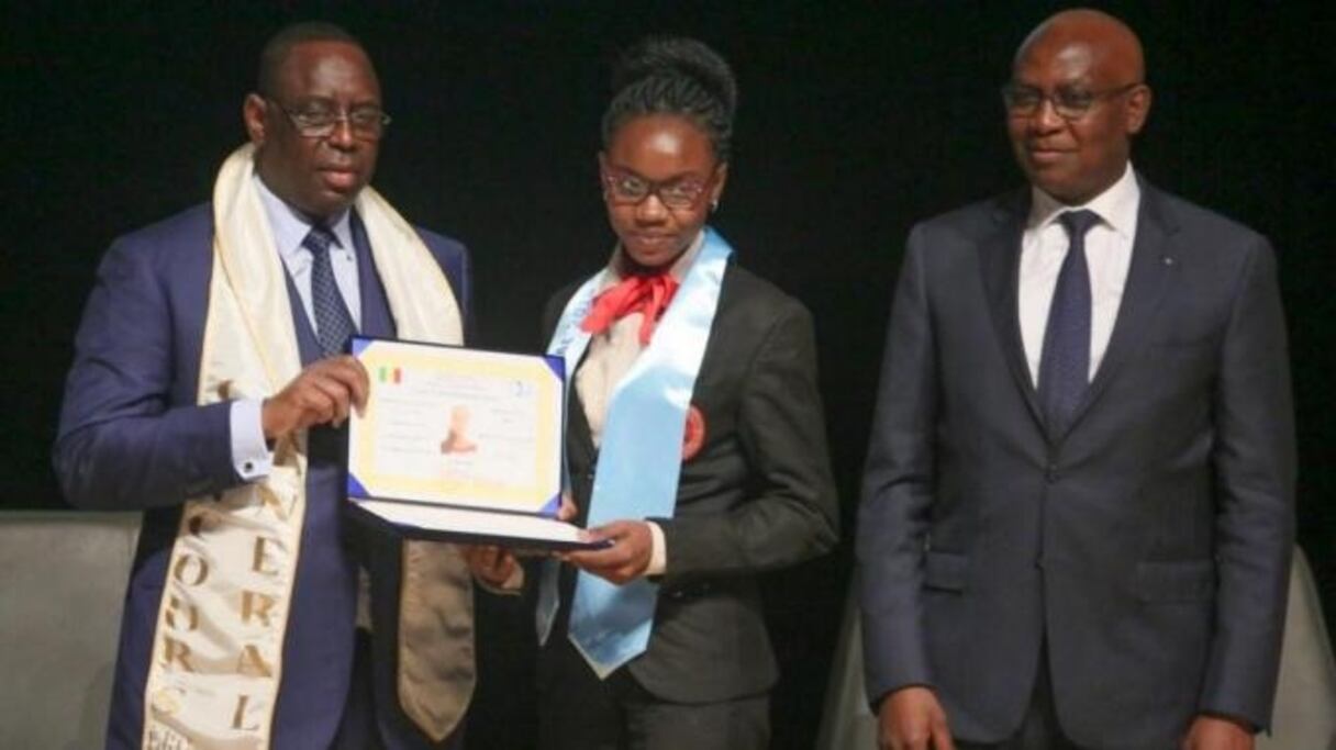 Le président Macky Sall donnant à Diarry Sow le prix de meilleure élève du concours général. 
