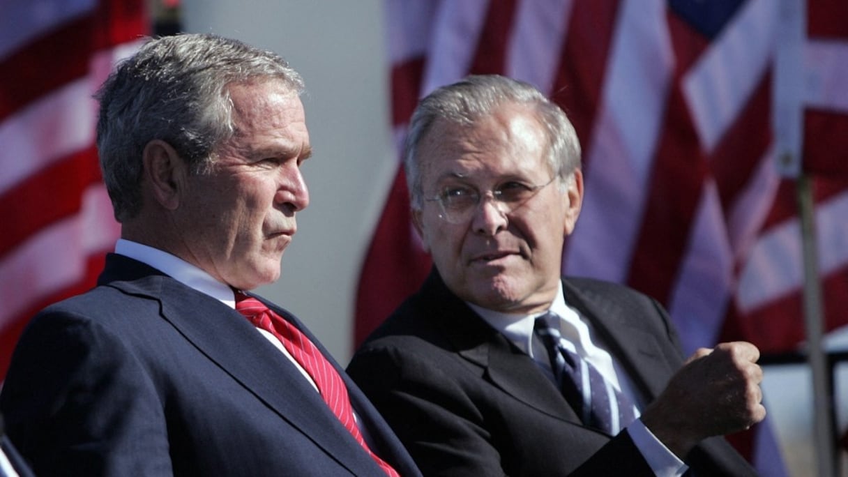 Le président américain George W. Bush (à gauche) s'entretient avec le secrétaire à la Défense Donald Rumsfeld (1933-2021), lors de la cérémonie commémorative de l'US Air Force à Arlington, en Virginie, le 14 octobre 2006 (archives).