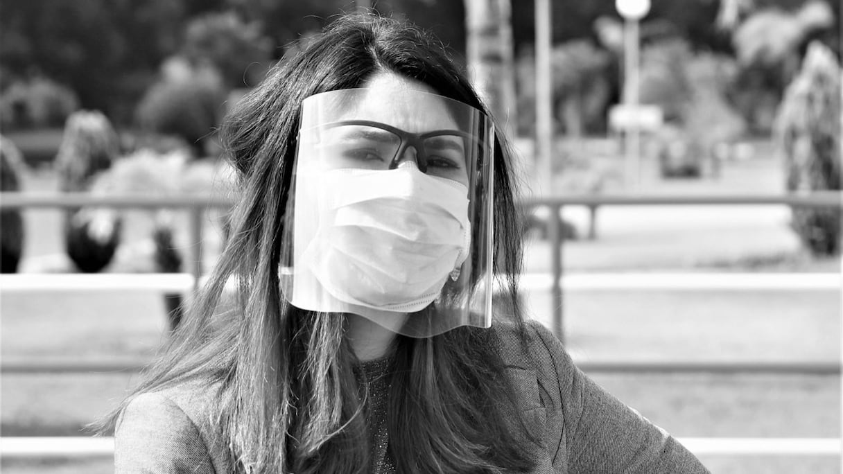 Une jeune Marocaine portant masque et visière de protection contre le coronavirus.
