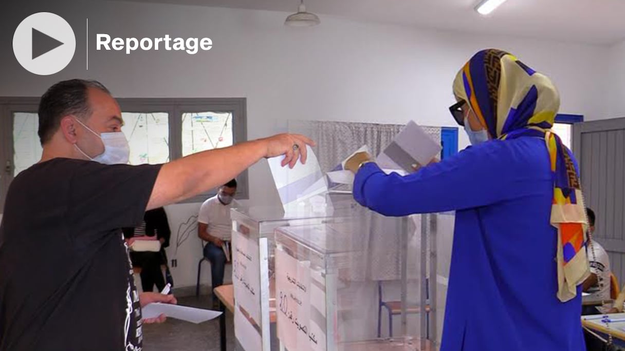 Des électeurs glissent leur bulletin de vote dans l'urne et s'acquittent de leur devoir électoral, lors des scrutins législatifs, régionaux et municipaux du 8 septembre 2021, à l'école Abderrahmane Anegay, dans le centre-ville de Tanger. 
