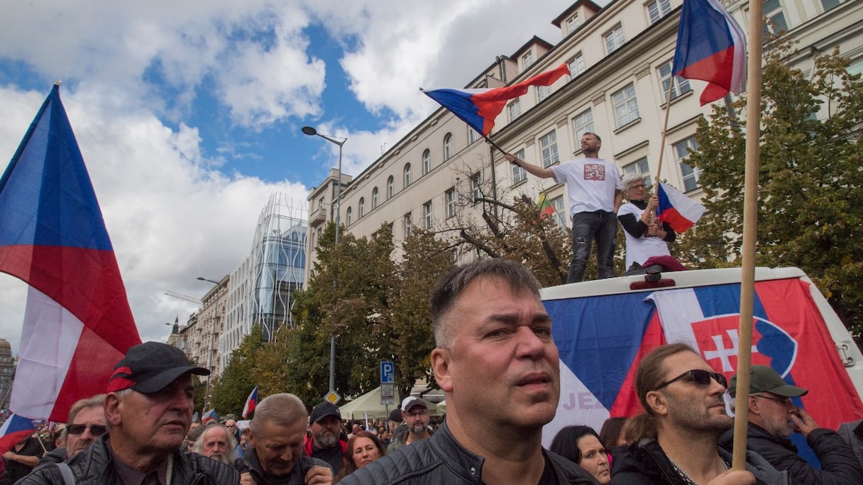 Plusieurs milliers de manifestants, dont des groupes d'extrême-droite et d'extrême-gauche, agitent des drapeaux nationaux alors qu'ils participent à un rassemblement contre le gouvernement, le 28 septembre 2022 à Prague, en Tchéquie.
