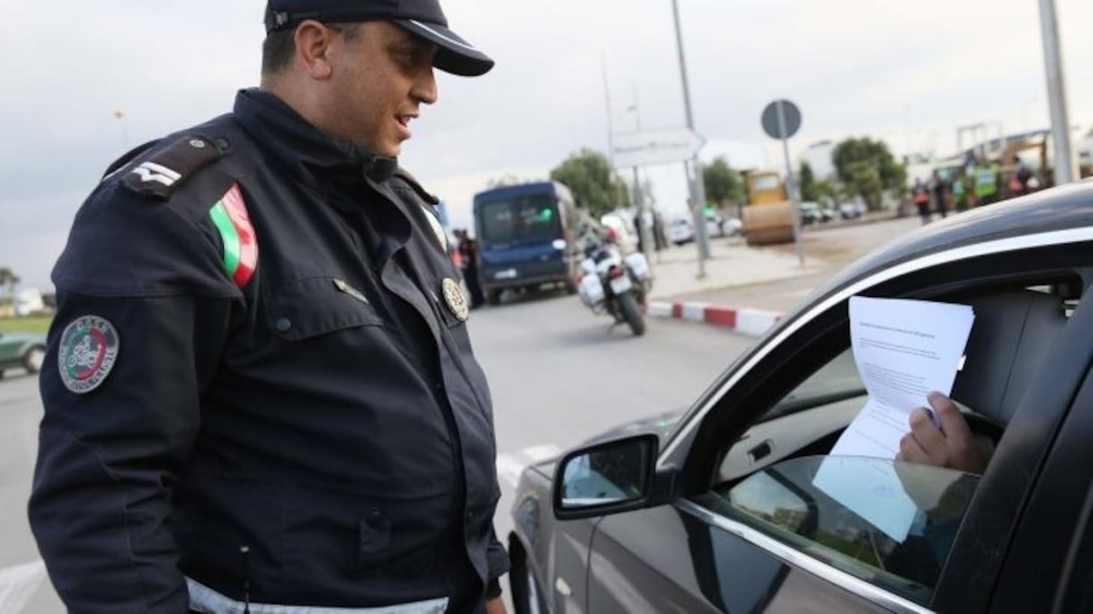 Un agent des forces de l'ordre contrôle les déplacements des citoyens pendant l'état d'urgence sanitaire. 
