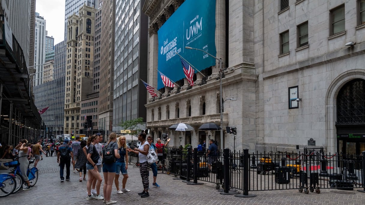 Des personnes marchent près de Wall Street, dans le quartier financier de Manhattan, le 18 juillet 2022 à New York.
